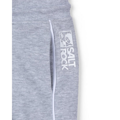 Close-up view of a hip pocket and raised white logo print on kids Saltrock Tok Corp jogger trousers in grey with white piping trim