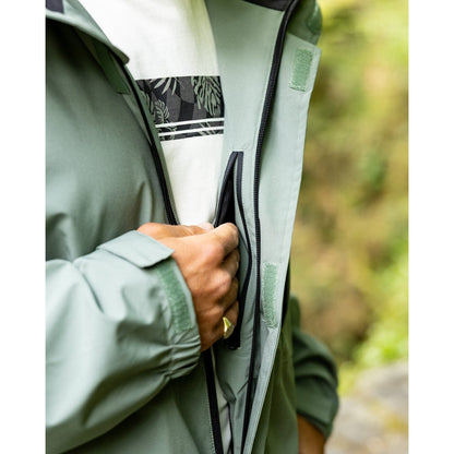 Close-up view of an internal zip pocket of a Saltrock Whistler II waterproof hooded jacket in light green outdoors