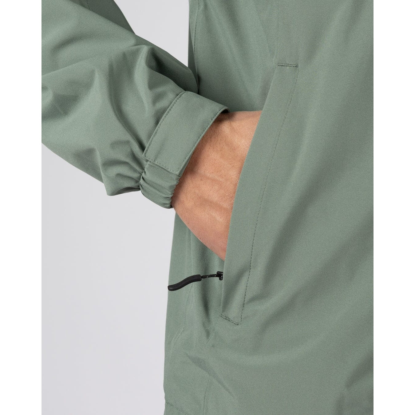 Close-up view of a tummy zip pocket on a mens Saltrock Whistler II waterproof hooded jacket in light green