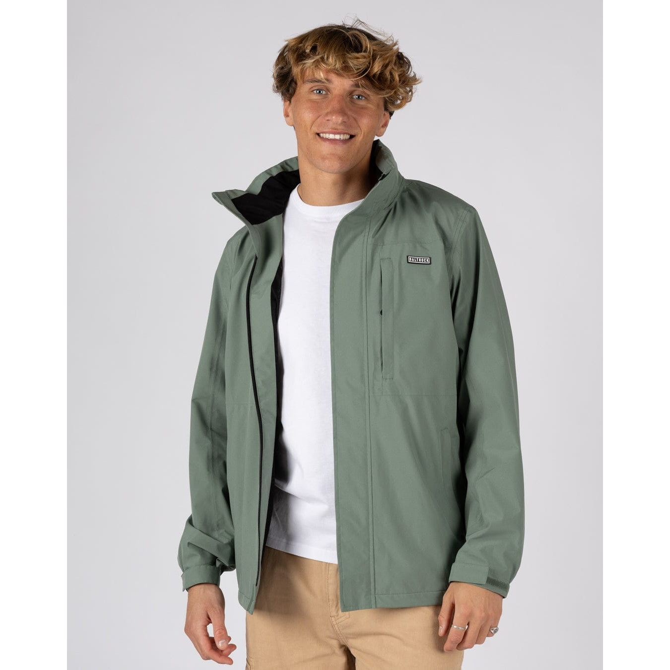 Front view of a man wearing an unzipped Saltrock Whistler II waterproof hooded jacket in light green