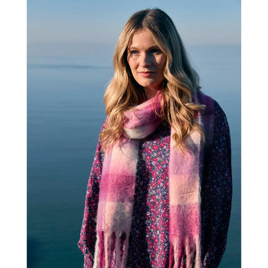Woman wearing a pink Saltrock Harvest scarf with a scenic background