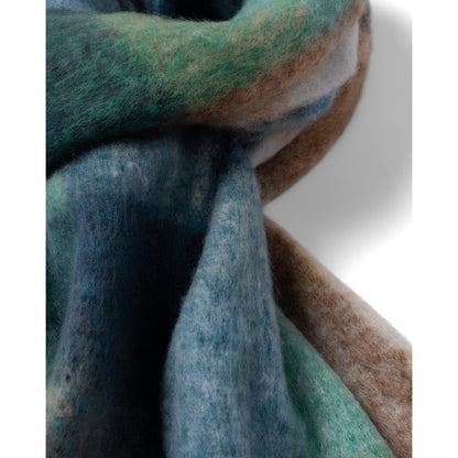Close up of a Saltrock Harvest scarf acrylic fabric in green blue and brown on a white background