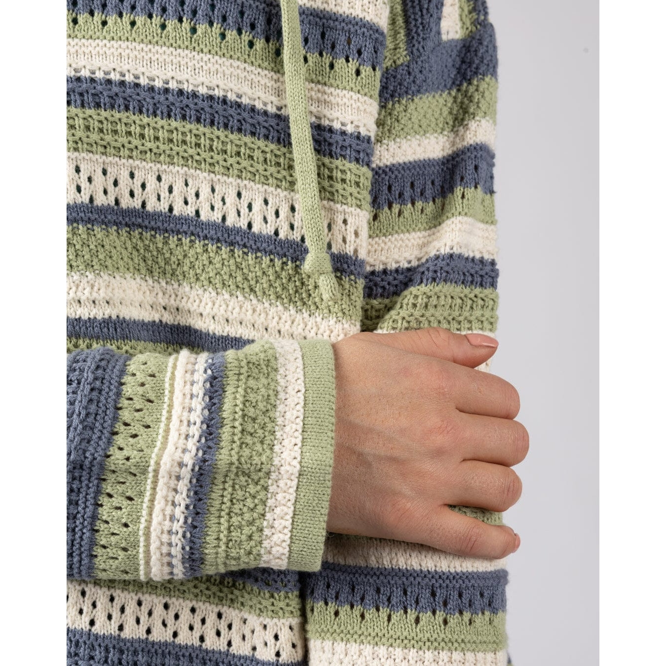 Close-up of a womens striped Saltrock Aurelia knitted hoodie in light green, blue and white