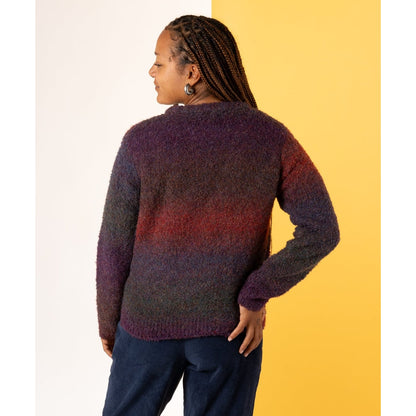 Back view of a woman wearing a Saltrock Bowden jumper with a dark purple and red gradient effect on a two-tone background