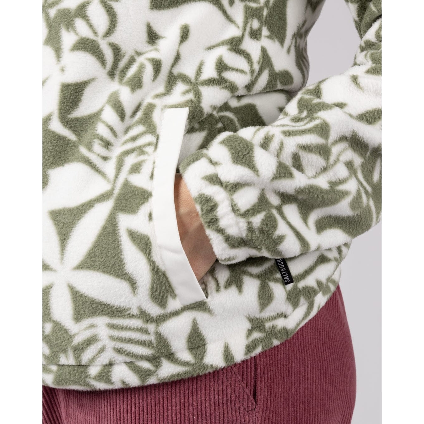 Close-up of a womens Saltrock balance fleece in a green floral pattern with tummy pocket and elasticated cuffs.