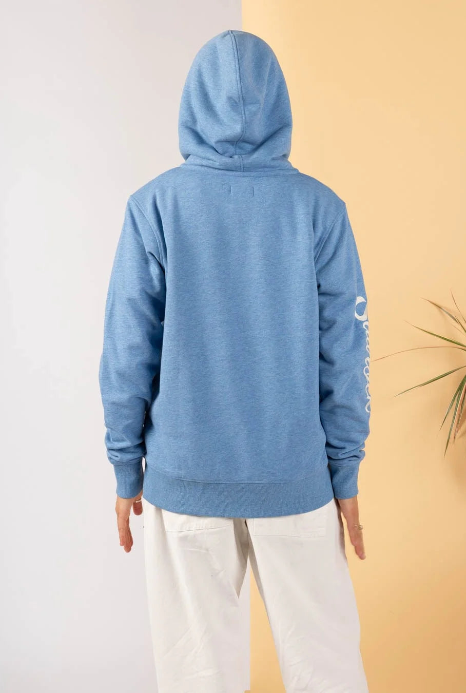 Saltrock womens blue lined hoodie shown from the back with hood up and white pants