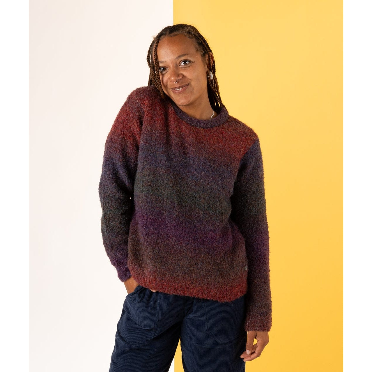 Woman wearing a Saltrock dark purple and red gradient knitt Bowden jumper against a yellow and white background