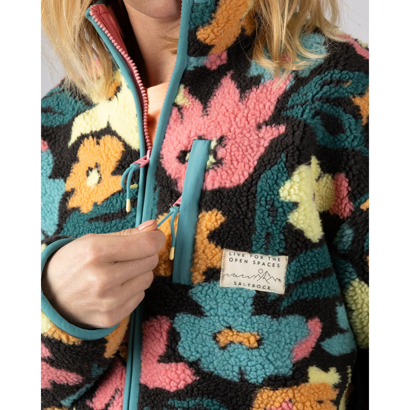Close-up view of a zip pocket on the chest of a womens Saltrock multicolour floral Holidaze sherpa fleece