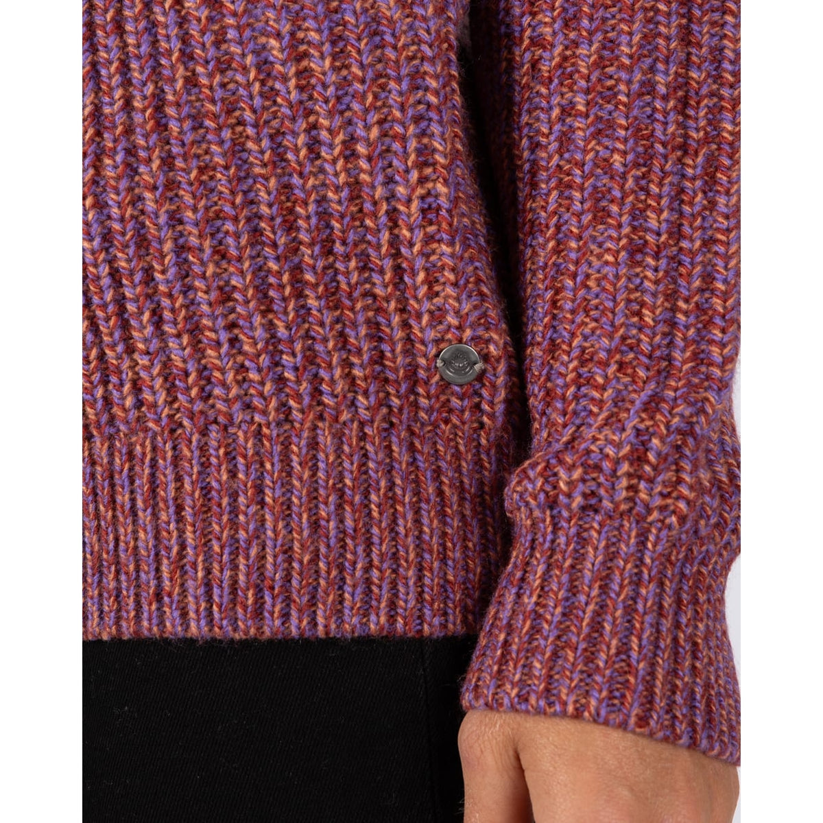 Close-up view of the hem and logo fob on a womens Saltrock Lucy crew neck longline knitted jumper in purple.