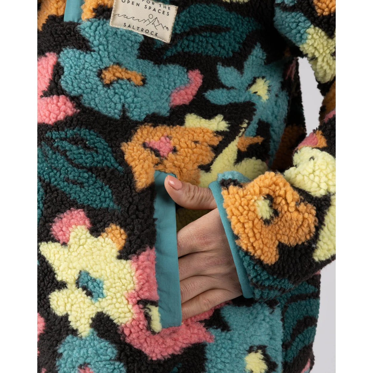 Close-up view of a tummy pocket on a womens Saltrock multicolour floral Holidaze sherpa fleece