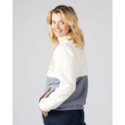 Side view of a woman wearing a Saltrock Denya full zip fleece in cream on a plain background