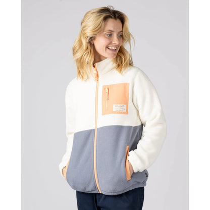 Woman wearing a Saltrock Denya full zip fleece jacket in cream, blue and coral with a chest pocket on a plain background
