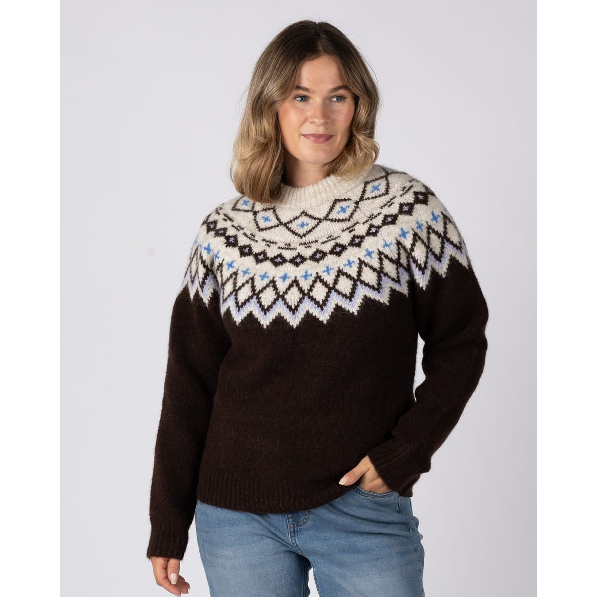 Front view of a woman wearing a Saltrock Fern jumper in brown with a Fairisle style cream, blue and brown pattern across the chest and shoulders.