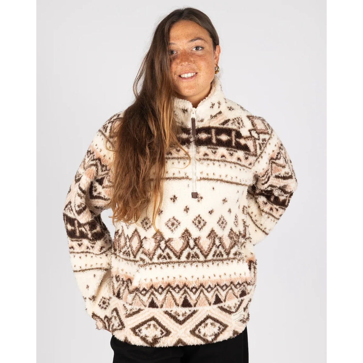 Front view of a woman wearing a Saltrock 1/4 zip Skylar fleece in cream with a brown geometric pattern