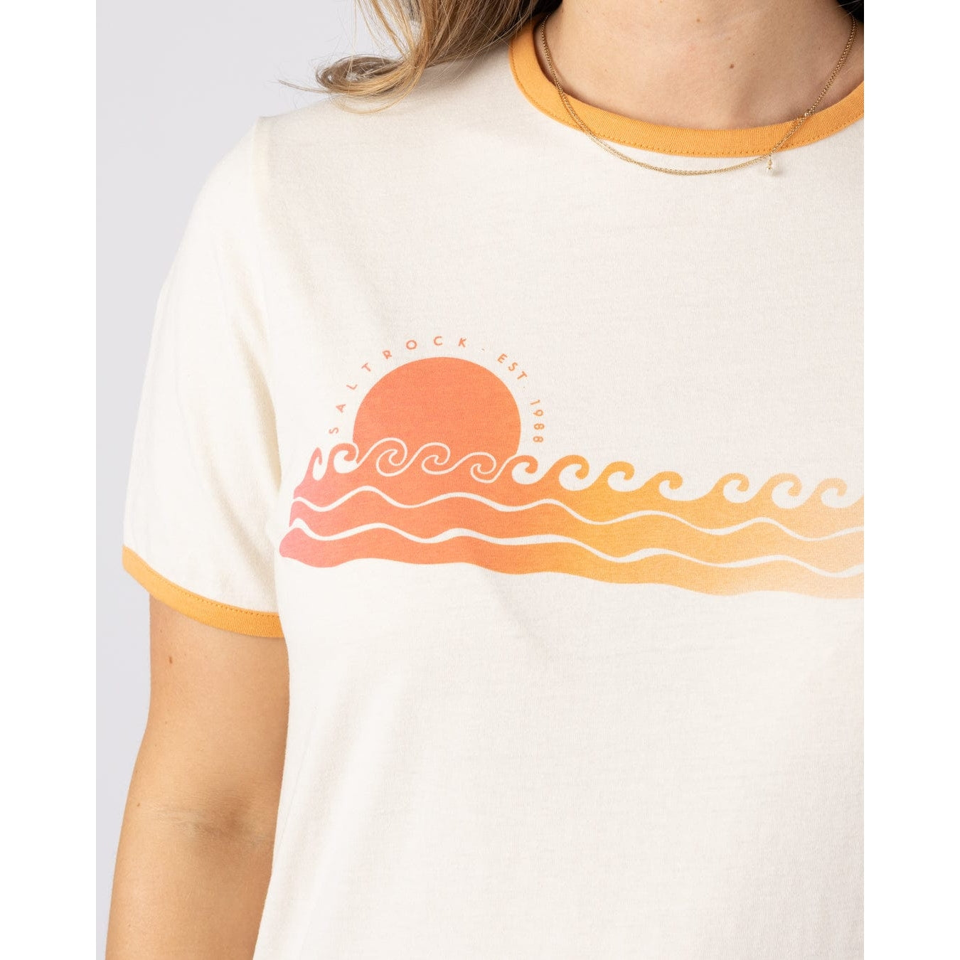 Close-up view of a womens Saltrock Golden Hour short sleeve t-shirt with a sunset and sea graphic print on the chest.