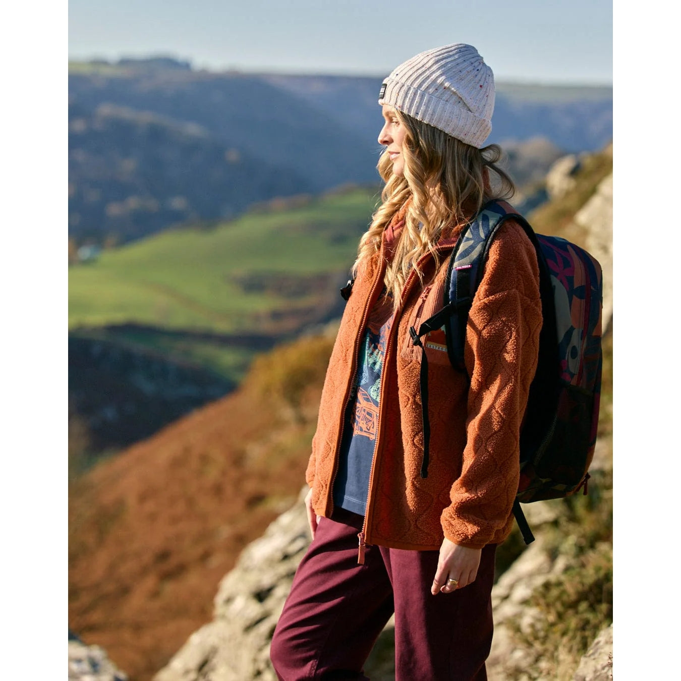 Woman standing on a mountain with a scenic view in the background