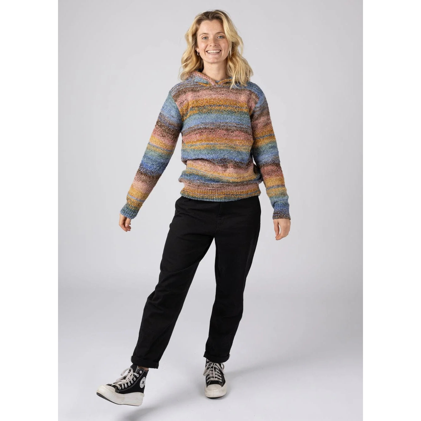 Woman wearing a multicolour striped Saltrock Space Dye Erin knitted hoodie and black pants