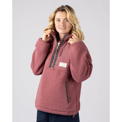 Front view of a woman wearing a Saltrock dark pink 1/4 zip Lya pullover fleece with a white background