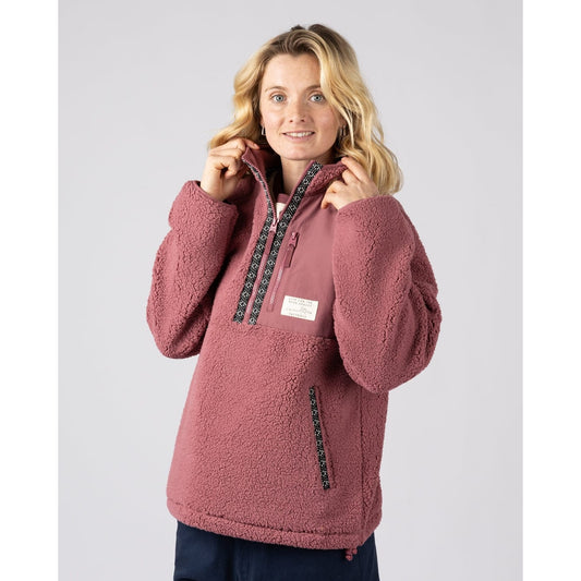 Front view of a woman wearing a Saltrock dark pink 1/4 zip Lya pullover fleece with a white background