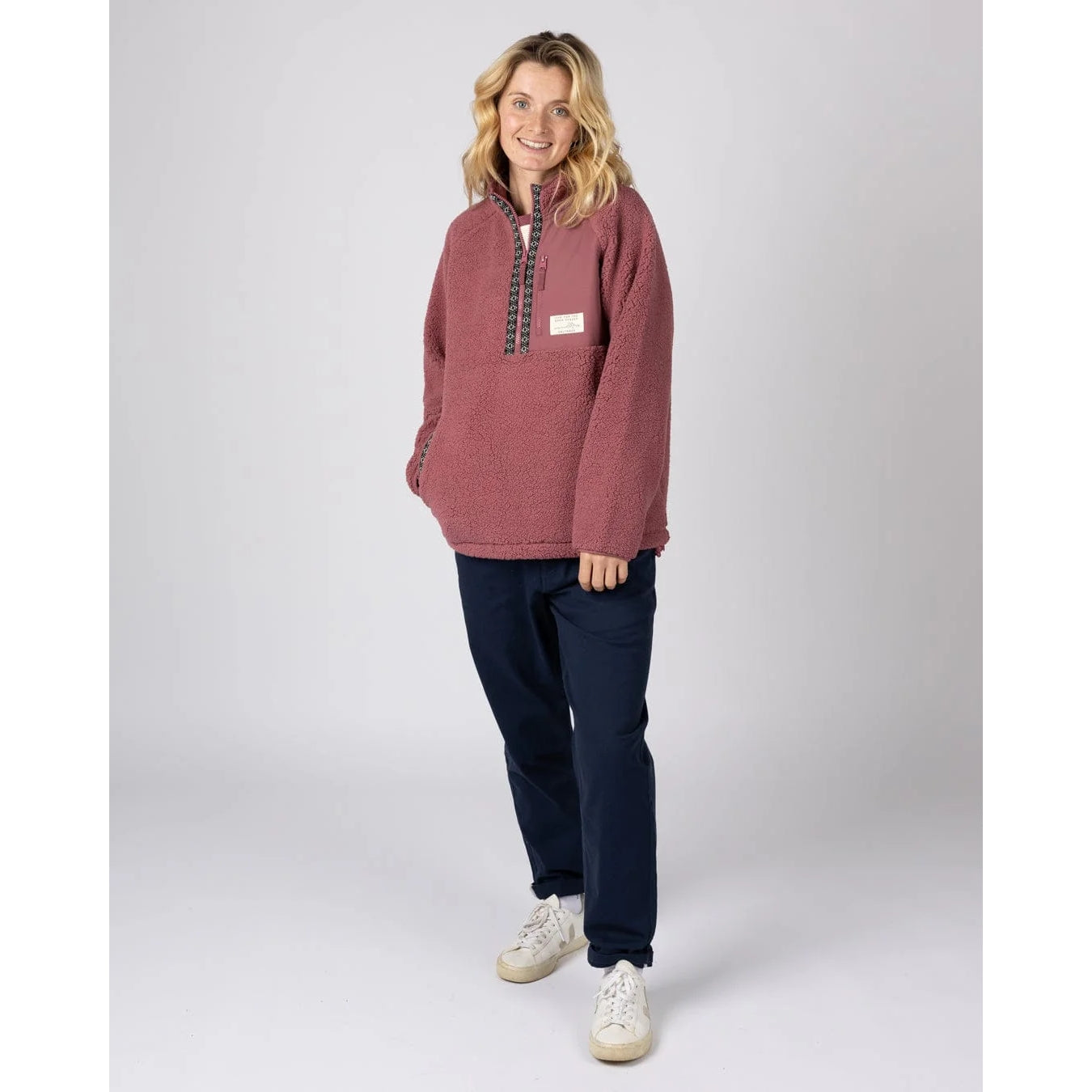 Woman wearing a dark pink Saltrock Lya pullover fleece with a white background