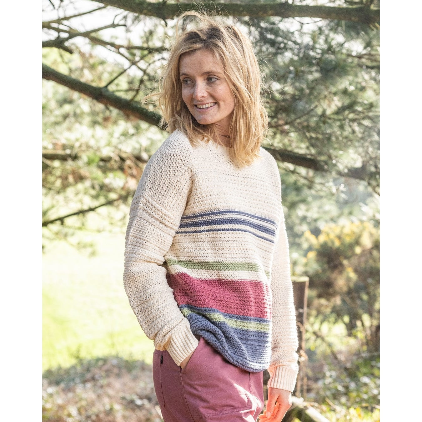 Front view of a woman wearing a Saltrock knitted crew neck Sable jumper in Cream with a multicolour stripe pattern