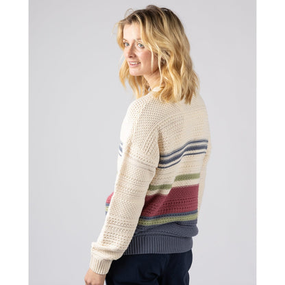 Side view of a woman wearing a cream  Saltrock Sable knitted jumper with colourful stripes