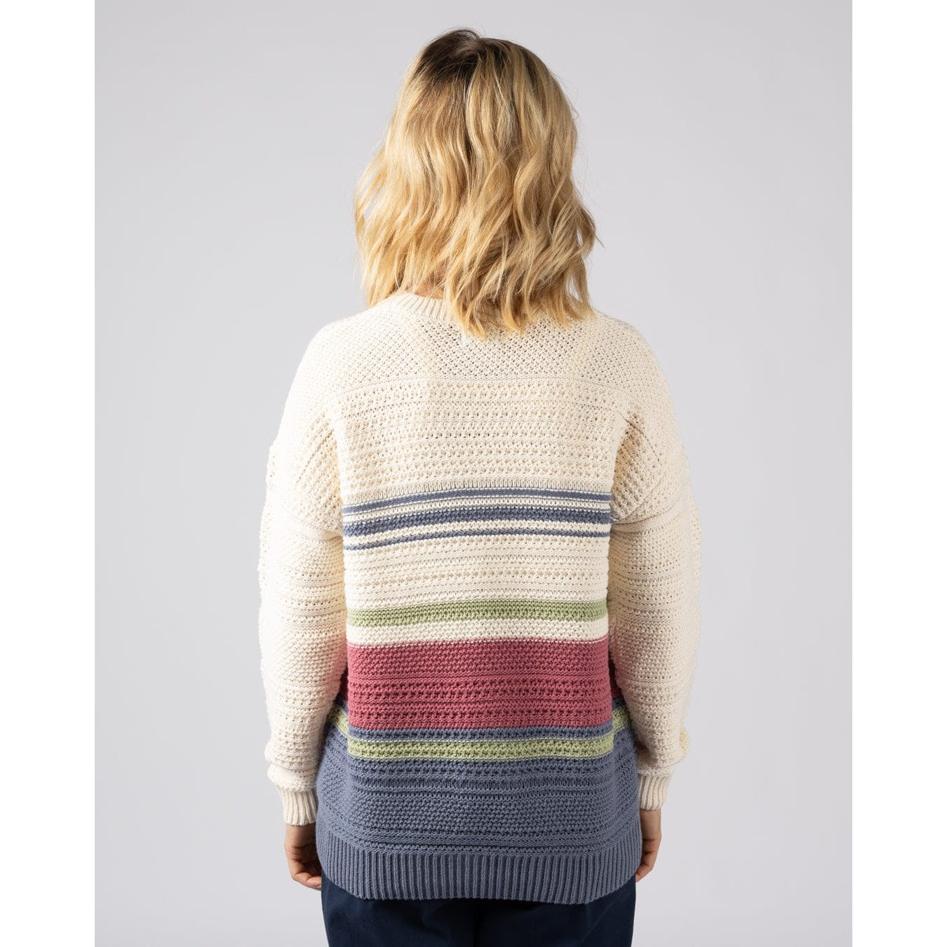 Back view of a woman wearing a cream  Saltrock knitted jumper with a colourful striped pattern