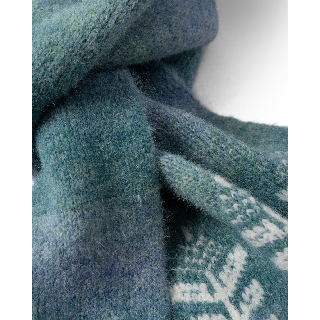 Close-up of a blue Saltrock knitted Quiver scarf with a patterned edge.