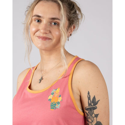 Close-up view of a woman wearing a bright pink Saltrock Sun Surfer vest top with a floral surfboard print on a plain background