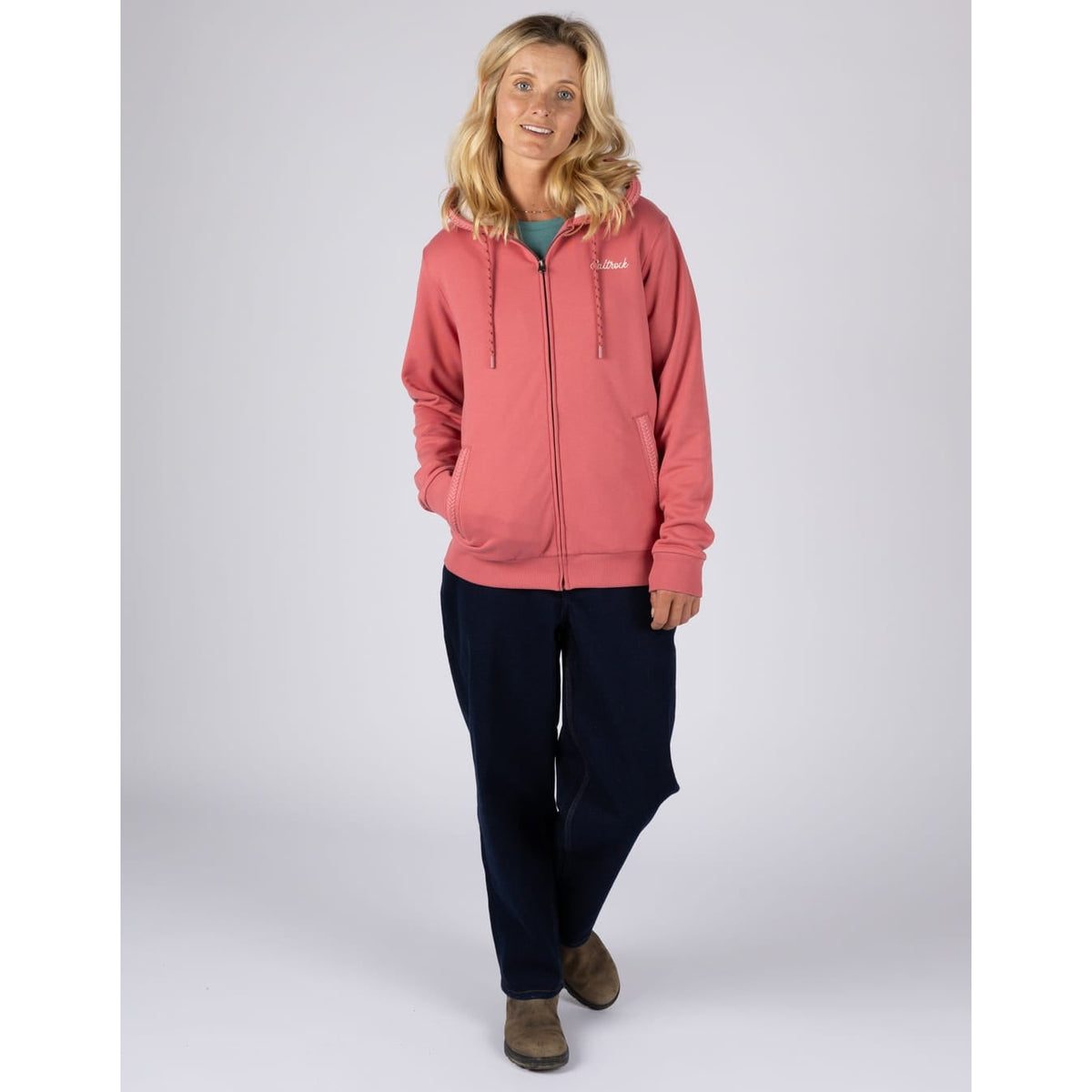 Front view of a woman wearing a Saltrock full zip Borg lined Tamsin hoodie in Pink with black trousers
