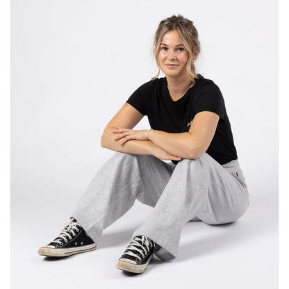 Woman wearing a pair of Saltrock sweat trousers in grey with a black t-shirt.