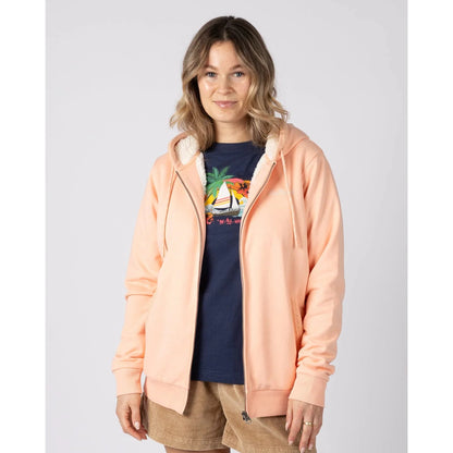Front view of a woman wearing a peach or light pink Saltrock Tamsin hoodie with borg lining over a navy graphic t-shirt on a white background