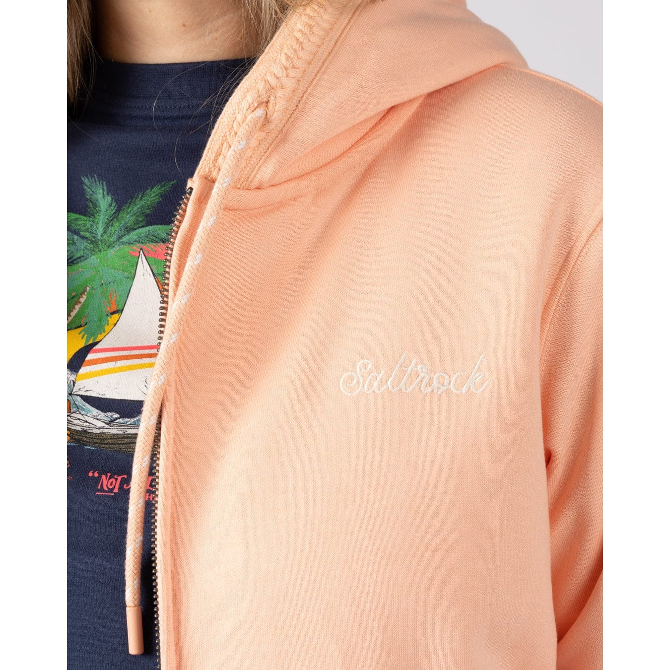 Close-up of a womens Saltrock Tamsin peach or light pink coloured hoodie with 'Saltrock' branding