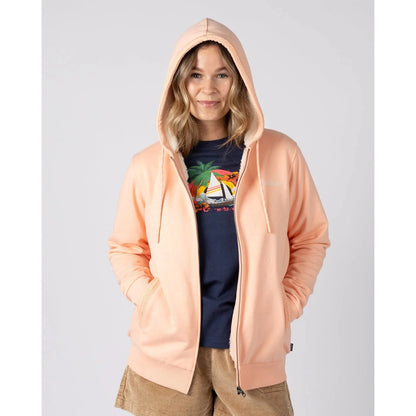 Front view of a woman wearing a peach or light pink coloured Saltrock borg lined Tamsin hoodie over a navy t-shirt, on a plain background