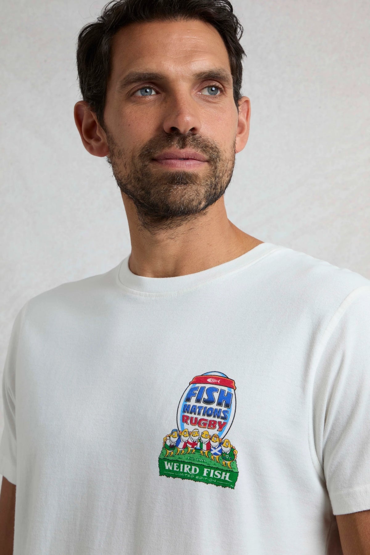 Man wearing a white Weird Fish t-shirt with a rugby themed 'Fish Nations Rugby' print on the chest.