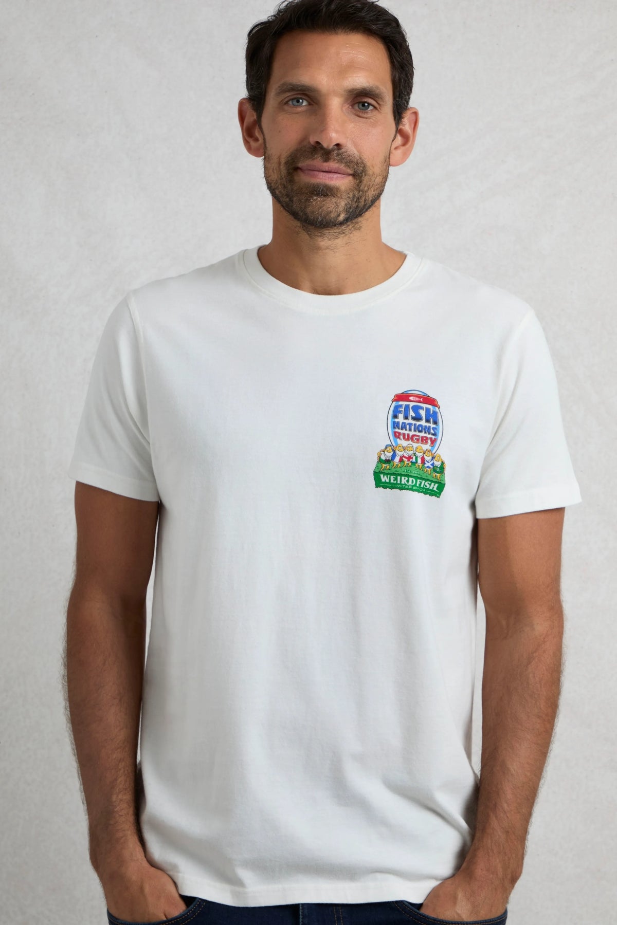 Man wearing a short sleeve white Weird Fish t-shirt with a small rugby themed Fish Nations print on one side of the chest, on a white background