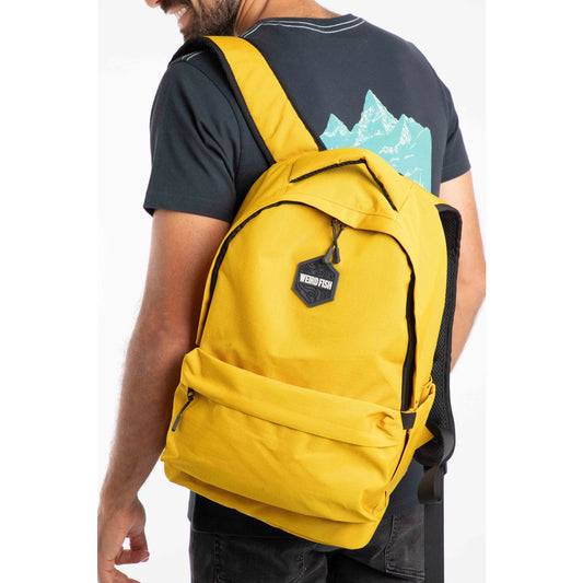 Main view of a person wearing a yellow Weird Fish Nevis backpack with a visible brand logo on a white background