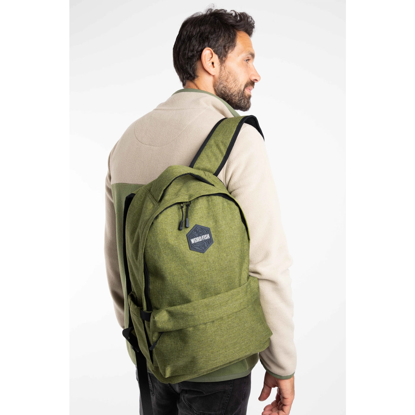 Man wearing a green Weird Fish Nevis backpack on a white background