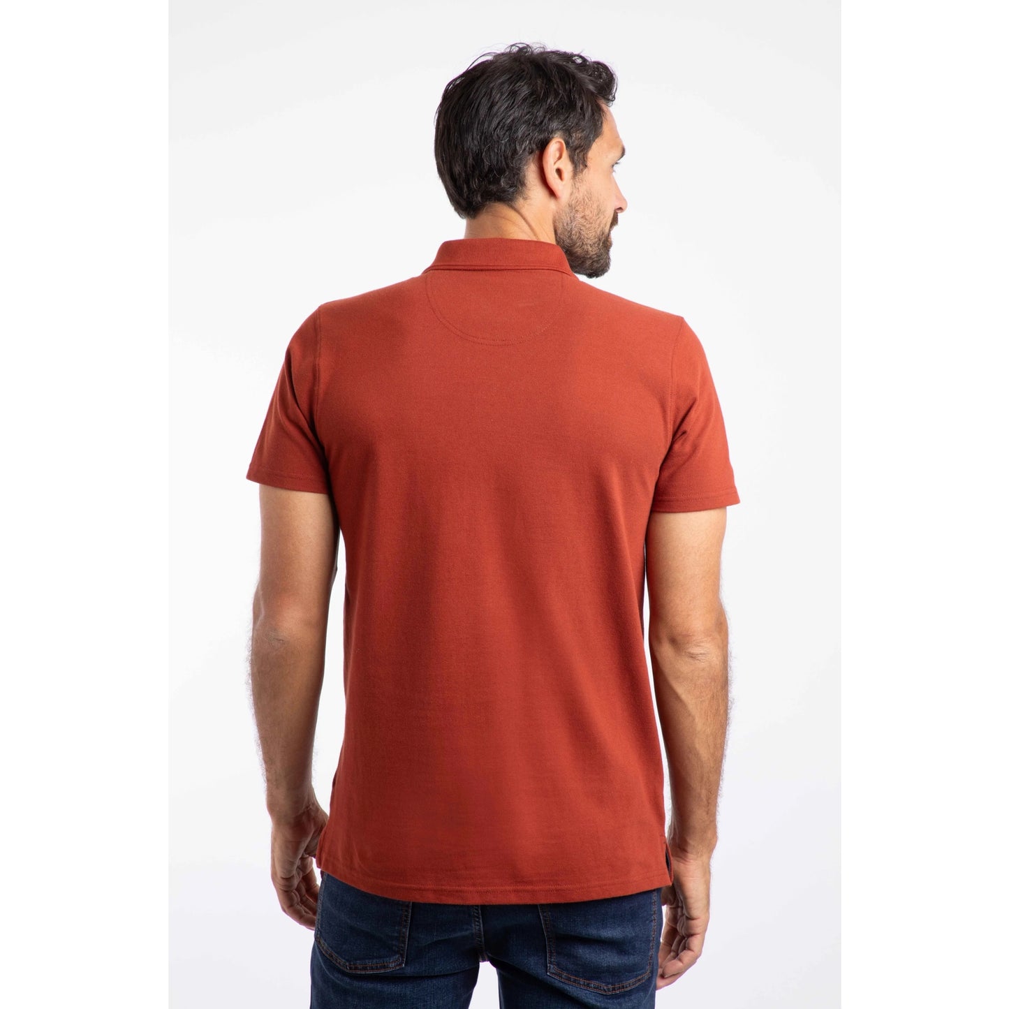 Back view of a man wearing a short sleeve Weird Fish Miles polo shirt in Burnt Henna.