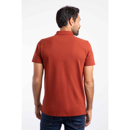 Back view of a man wearing a short sleeve Weird Fish Miles polo shirt in Burnt Henna.