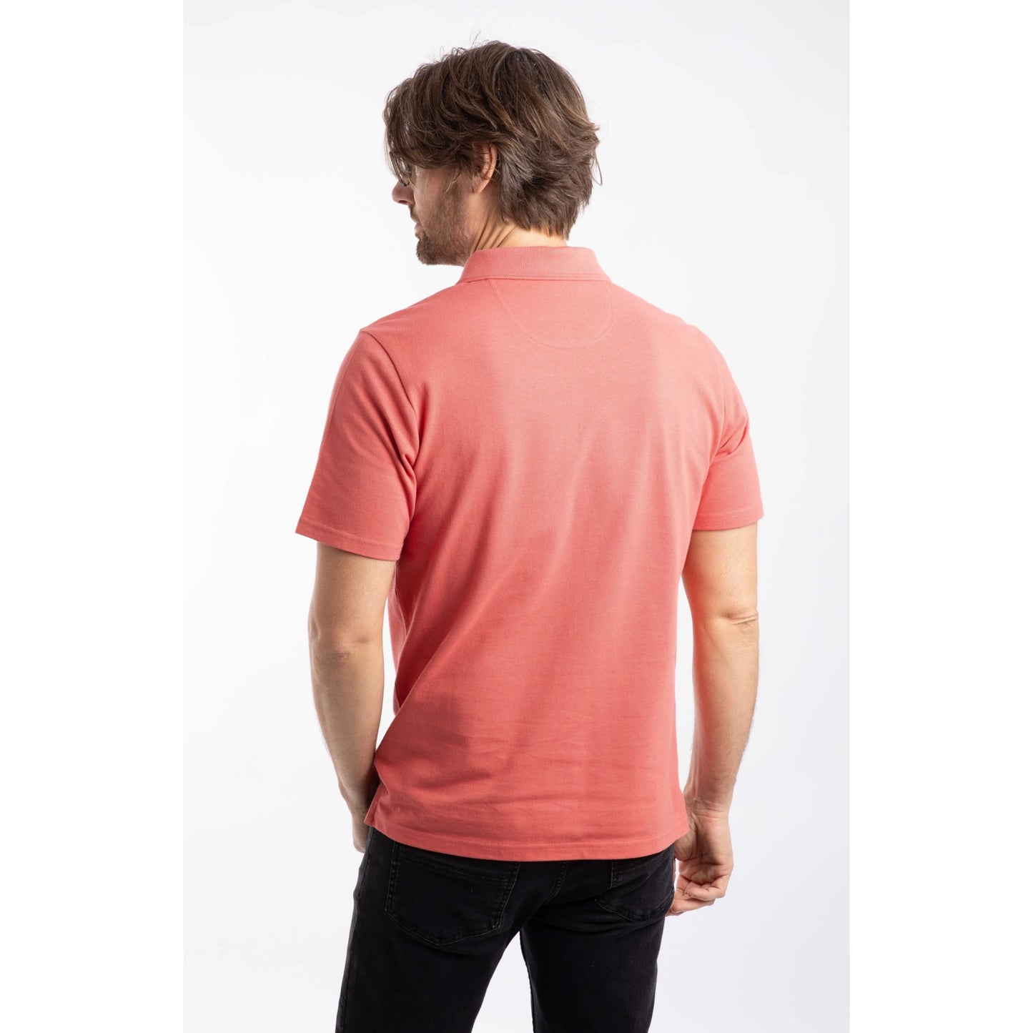 Back view of a man wearing a Weird Fish short sleeve Miles polo shirt in Nantucket coral.