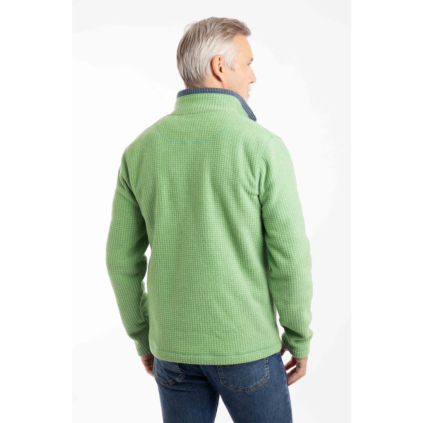 Back view of a man wearing a Weird Fish Newark 1/4 zip grid fleece in grass green, with blue jeans