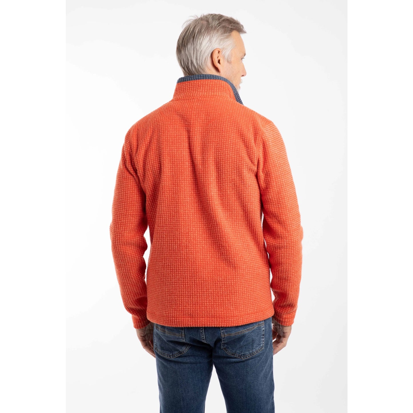 Back view of a man wearing a Weird Fish Newark 1/4 zip grid fleece in Orange Spice, with blue jeans