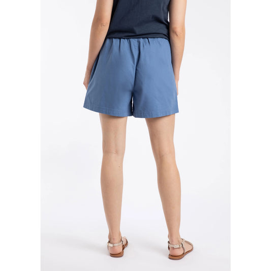 Back view of a woman wearing a pair of Weird Fish Jardin elastic waist twill cotton shorts in Faded Blue with hip pockets.