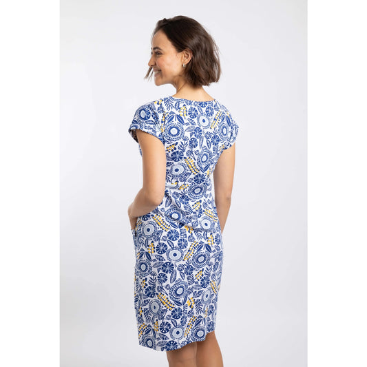 Back view of a woman wearing a Weird Fish short sleeve Tallahassee dress in Sapphire Blue featuring an abstract floral print and front pockets.