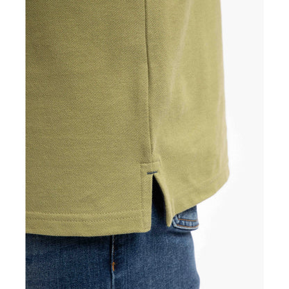 Close-up view of the side hem slit of a men's Weird Fish short sleeve Miles polo shirt in Washed Oak Green.