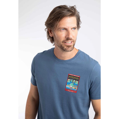 Close-up view of a man wearing a short sleeve t-shirt in Ensign Blue, featuring a small Shawshark Redemption parody print of The Shawshank Redemption film poster on one side of the chest.