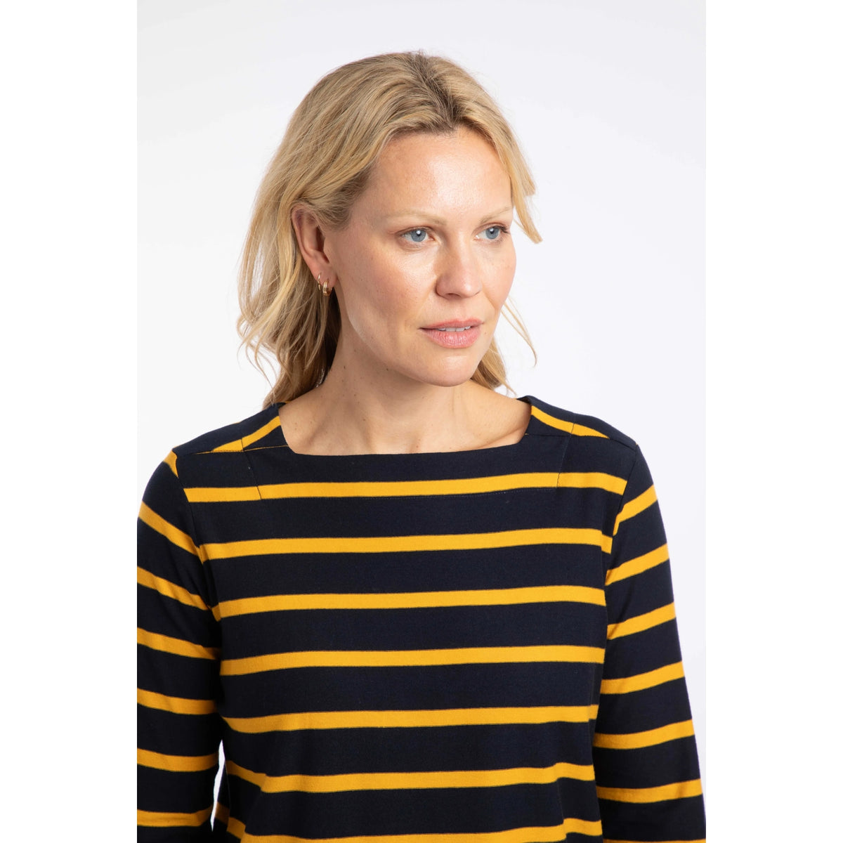 Close-up view of the square neckline of a woman wearing a Weird Fish Saffira 3/4 length sleeve top in Midnight Navy with Gold Yellow stripes.