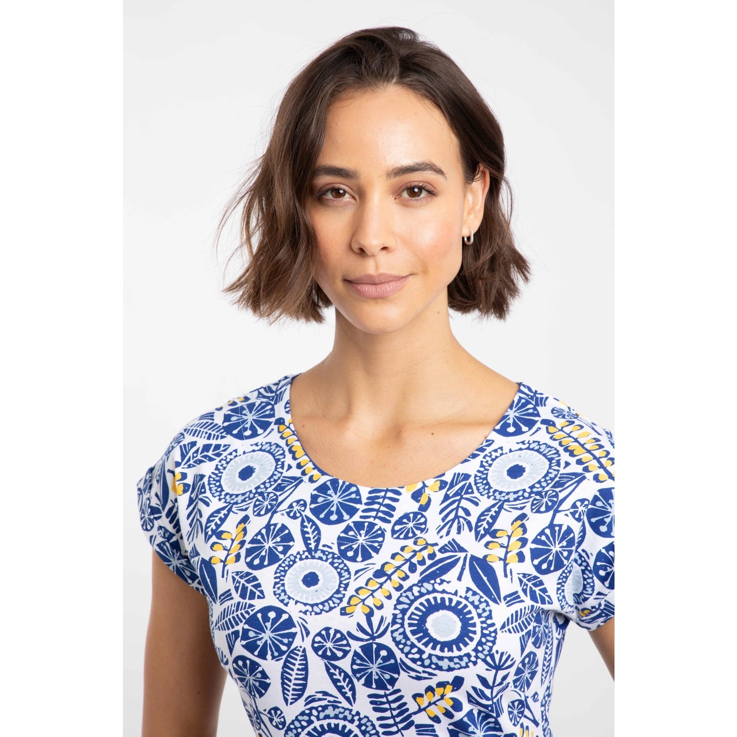 Close-up view of a woman wearing a Weird Fish short sleeve Tallahassee dress in Sapphire Blue featuring an abstract floral print.