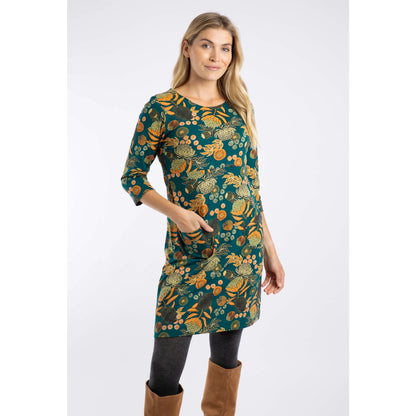 Woman wearing a Weird Fish Deep Teal Starshine dress with a multicolour floral pattern on a white background